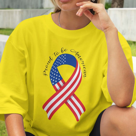 Person wearing a yellow t-shirt with an American flag ribbon design and text.