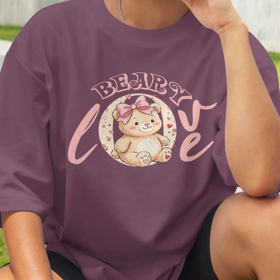 Person wearing a purple t-shirt with a teddy bear graphic and 'BEARLY LOVING' text.