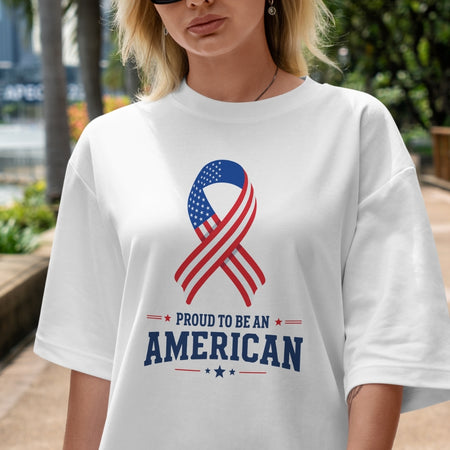 Person wearing a white t-shirt with an American flag ribbon design and 'Proud to be an American' text.