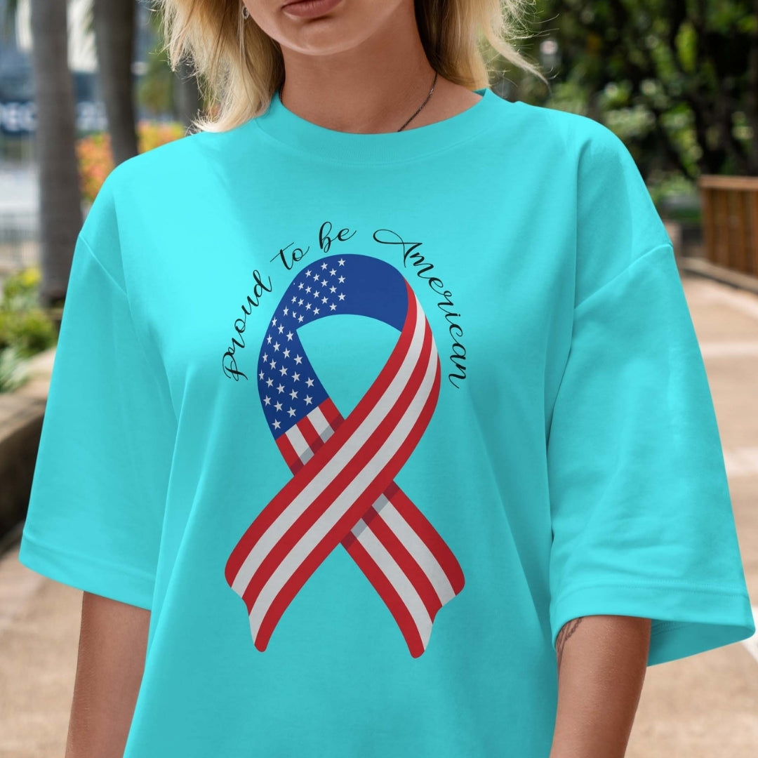 Person wearing a turquoise t-shirt with an American flag ribbon design and text.