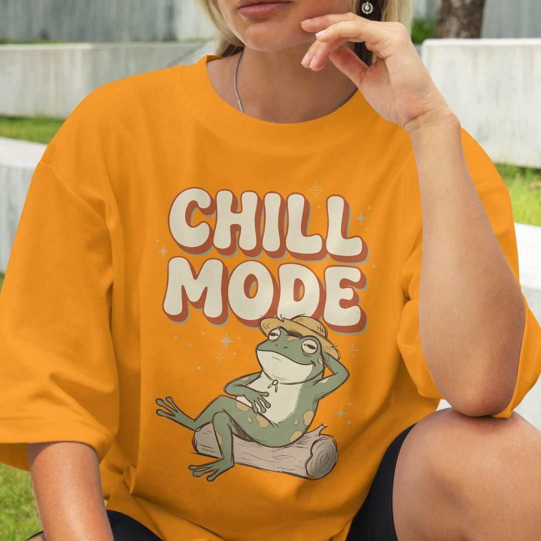 Person wearing an orange t-shirt with a frog graphic and 'Chill Mode' text.