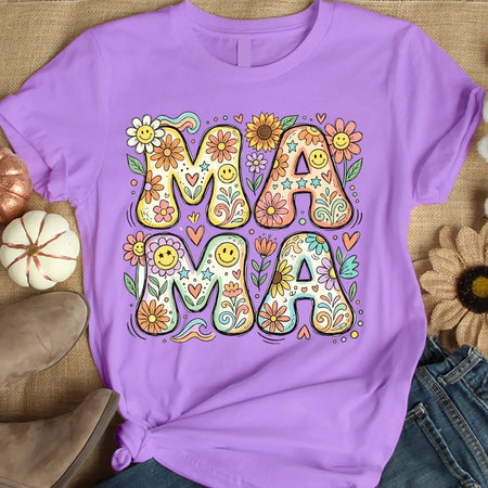 Purple t-shirt with 'MAMA' design featuring flowers and smiley faces on a textured surface.