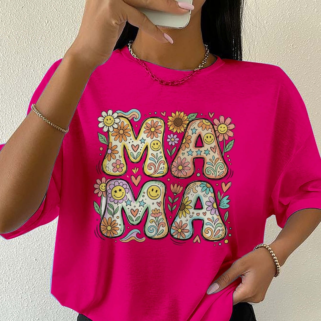 Person wearing a bright pink t-shirt with colorful 'MAIMA' design.