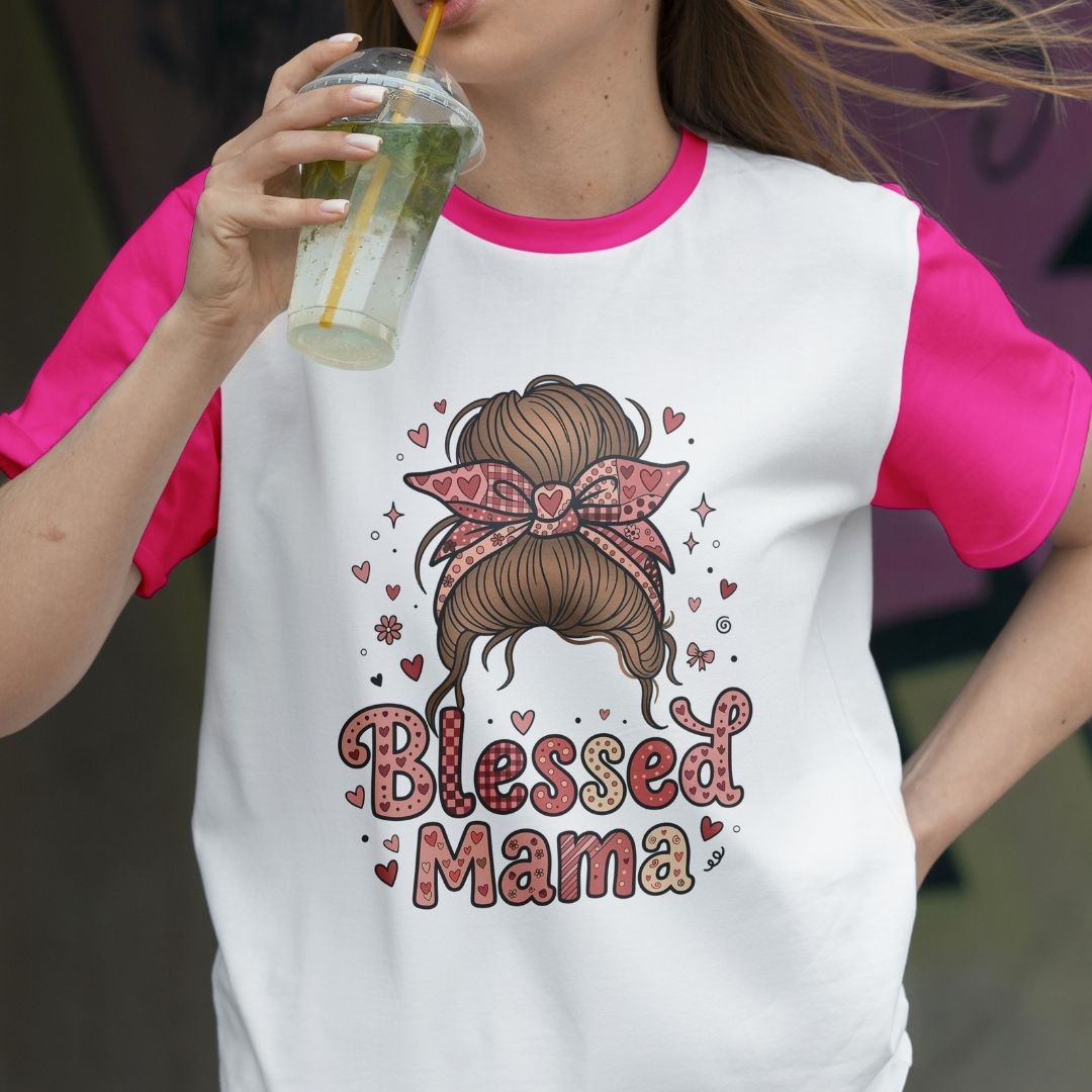 Person wearing a 'Blessed Mama' t-shirt with a graphic design, holding a drink.