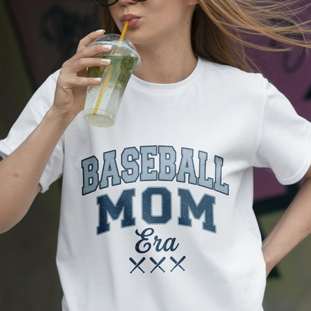 Woman wearing a 'Baseball Mom Era' t-shirt, holding a drink.