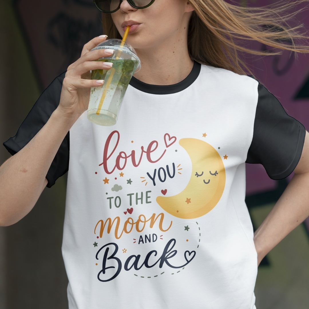 Person wearing a t-shirt with a moon and text design, holding a drink.