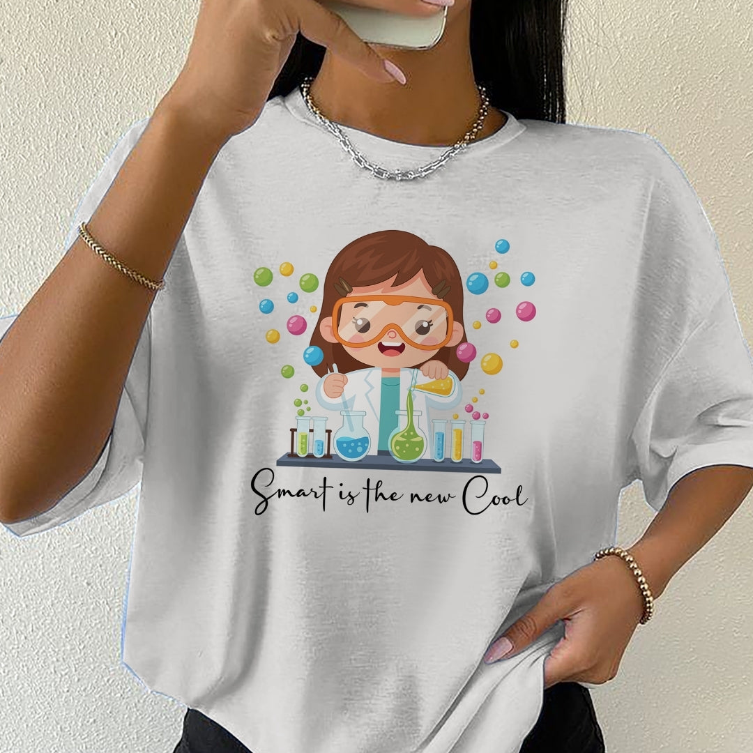 Person wearing a white t-shirt with a cartoon scientist design and text 'Smart is the new cool'.