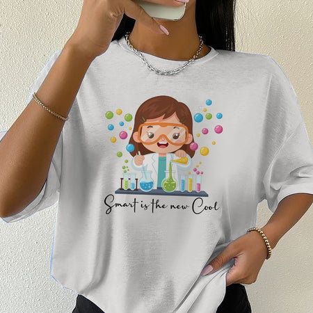 Person wearing a white t-shirt with a cartoon scientist design and text 'Smart is the new cool'.