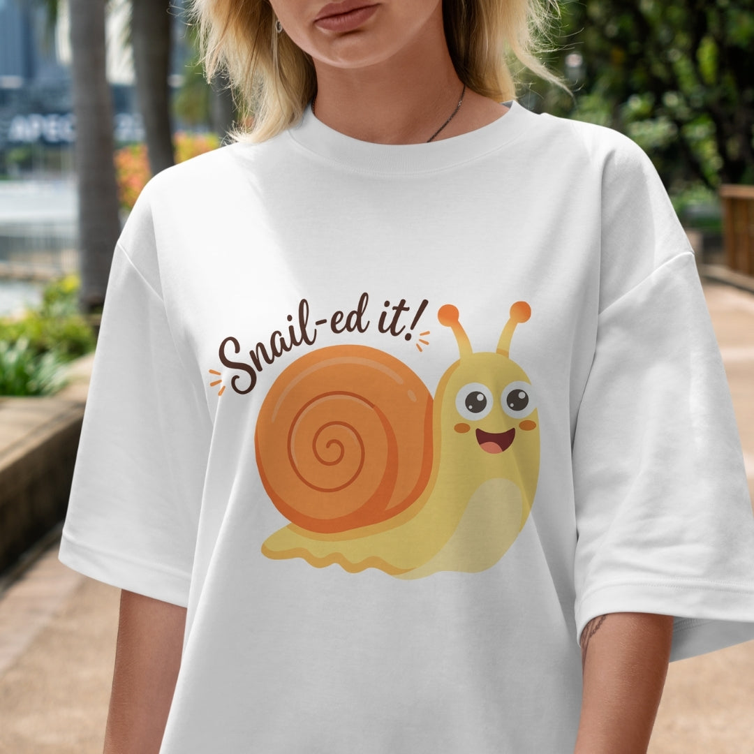 Person wearing a white t-shirt with a cartoon snail and 'Snail-ed it!' text.