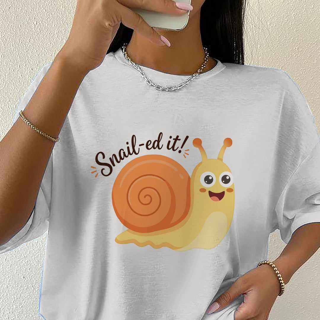 Person wearing a white t-shirt with a cartoon snail and 'Snail-ed it!' text.