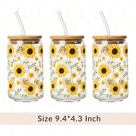 Three glass jars with sunflower designs, bamboo lids, and straws on a white background.