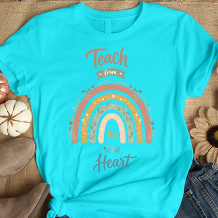 Turquoise t-shirt with rainbow and text design on a textured surface