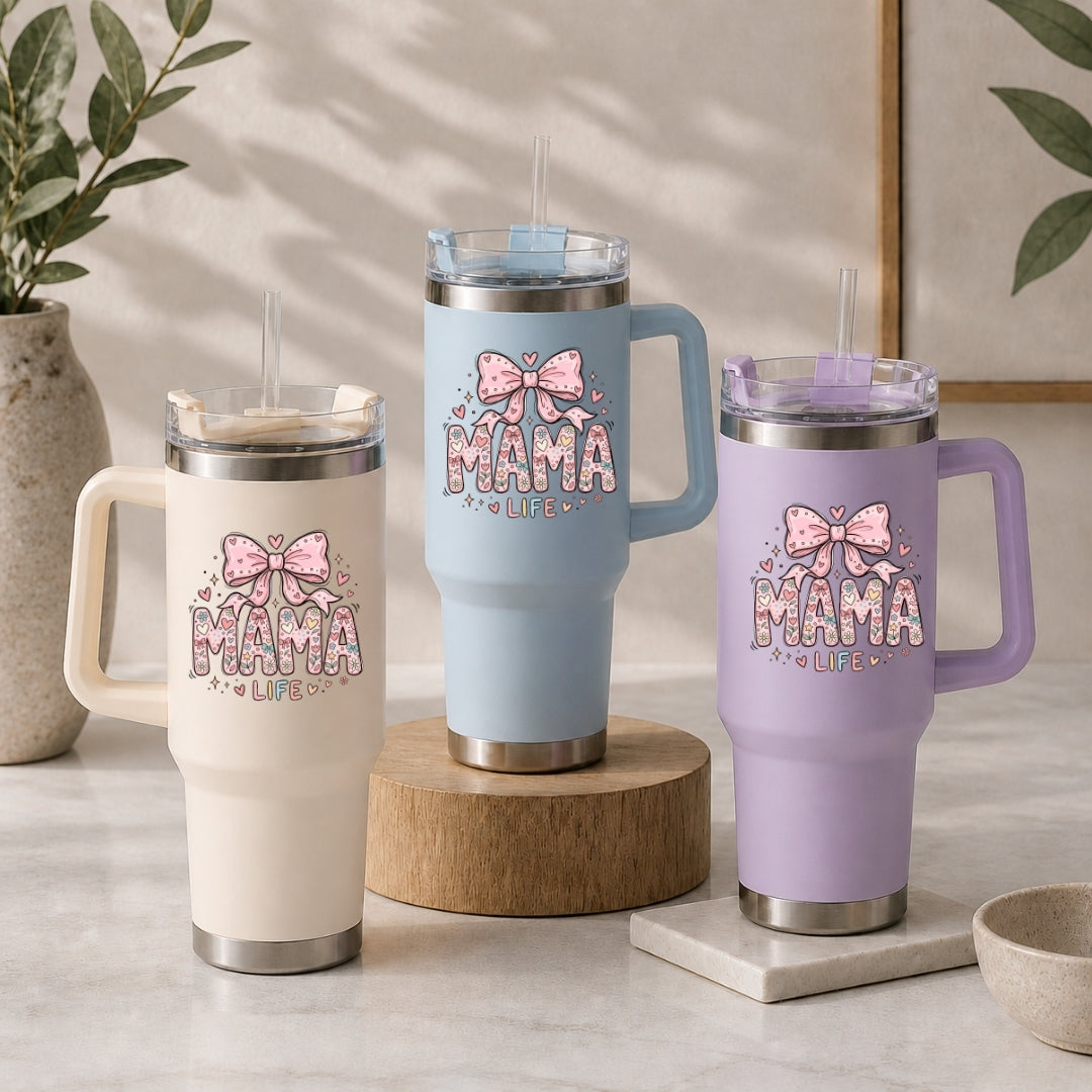 Three insulated mugs with 'MAMA LIFE' and bow designs on a neutral background.