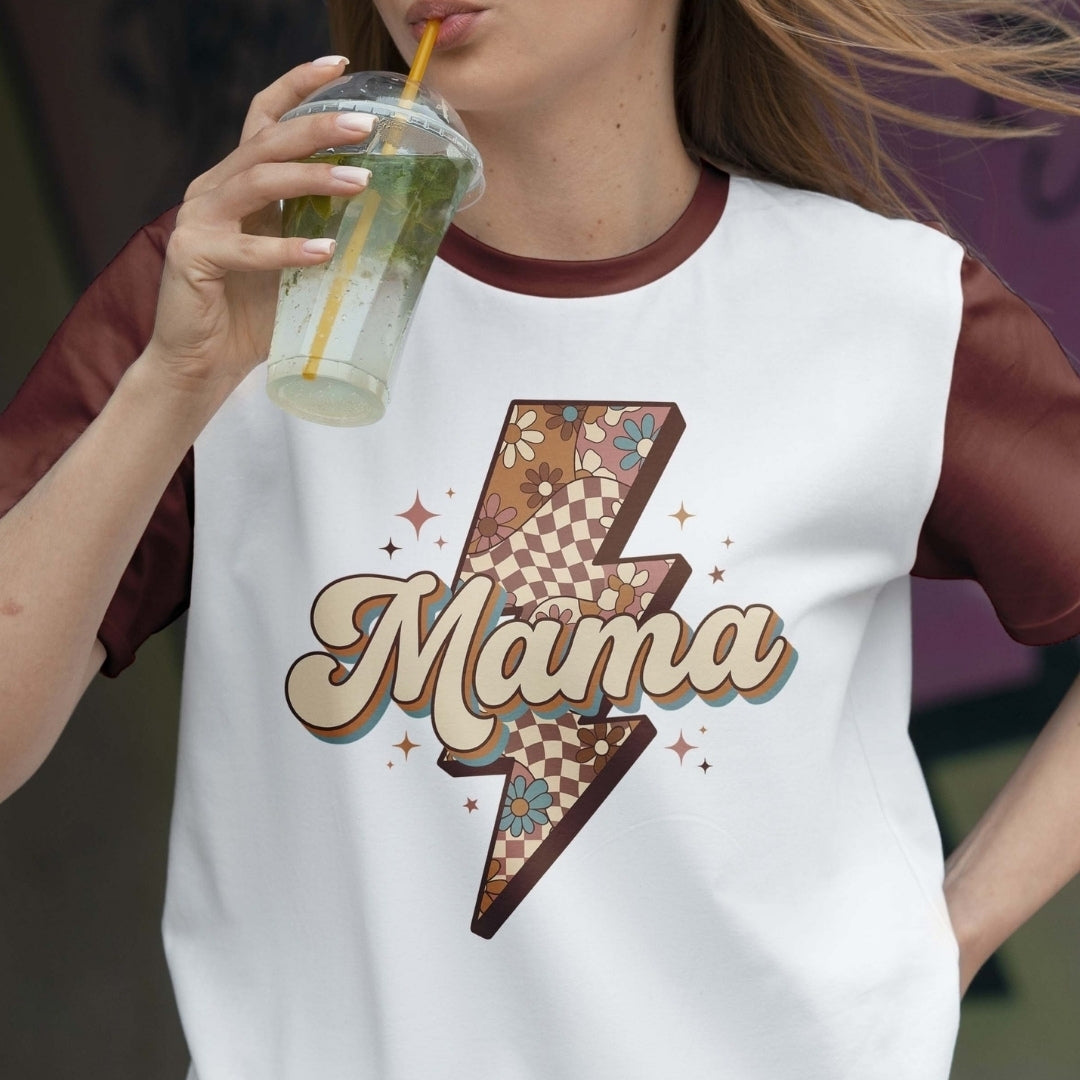Person wearing a white sleeveless shirt with 'Mama' design, holding a drink.