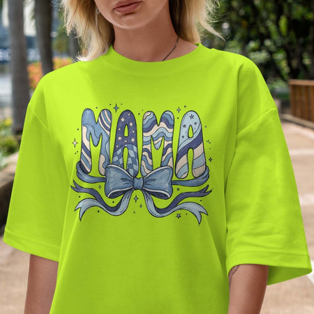 Person wearing a bright green t-shirt with 'Mama' design outdoors.