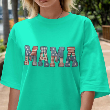 Person wearing a teal t-shirt with 'MAMA' printed in colorful letters.