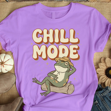 Purple t-shirt with a frog graphic and 'Chill Mode' text on a textured surface.