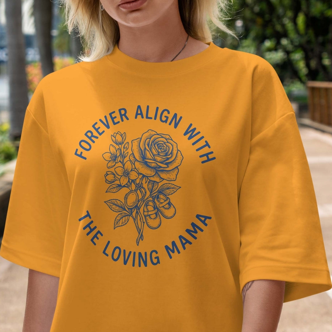 Person wearing a yellow t-shirt with a floral design and text outdoors.