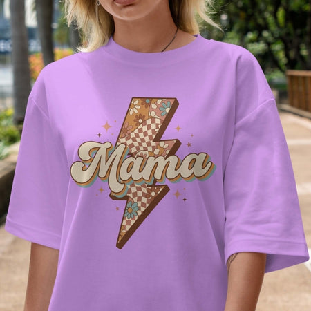 Person wearing a purple t-shirt with a 'Mama' graphic design outdoors.