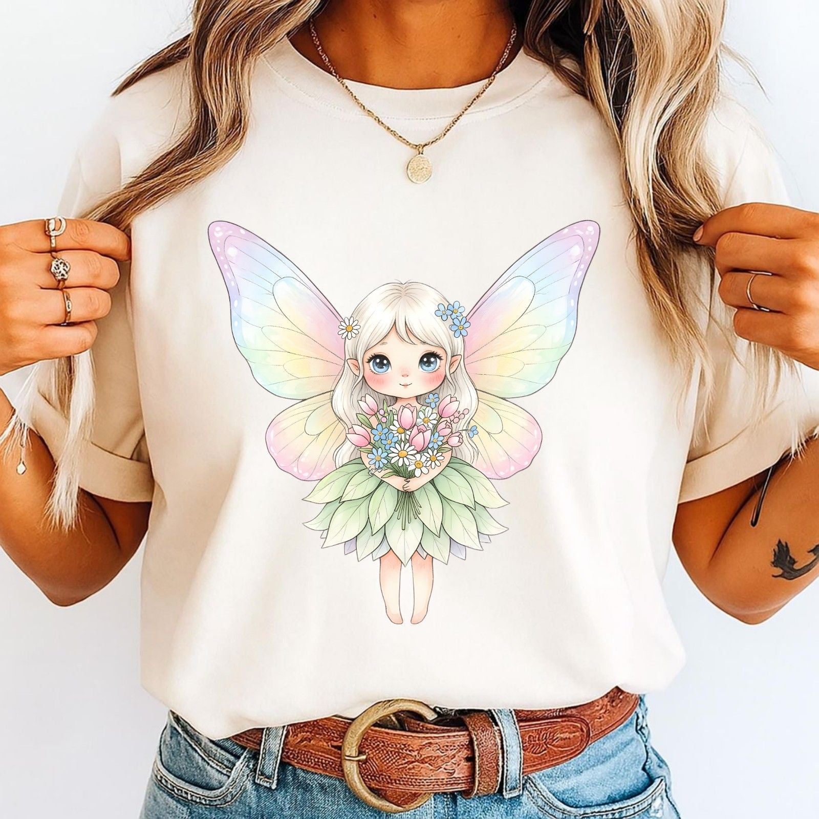 Person wearing a white t-shirt with a colorful fairy design.
