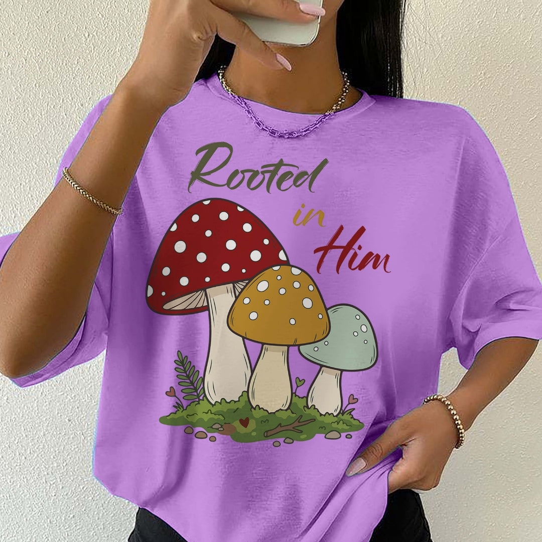Person wearing a purple t-shirt with mushroom design and text 'Rooted in Him'.