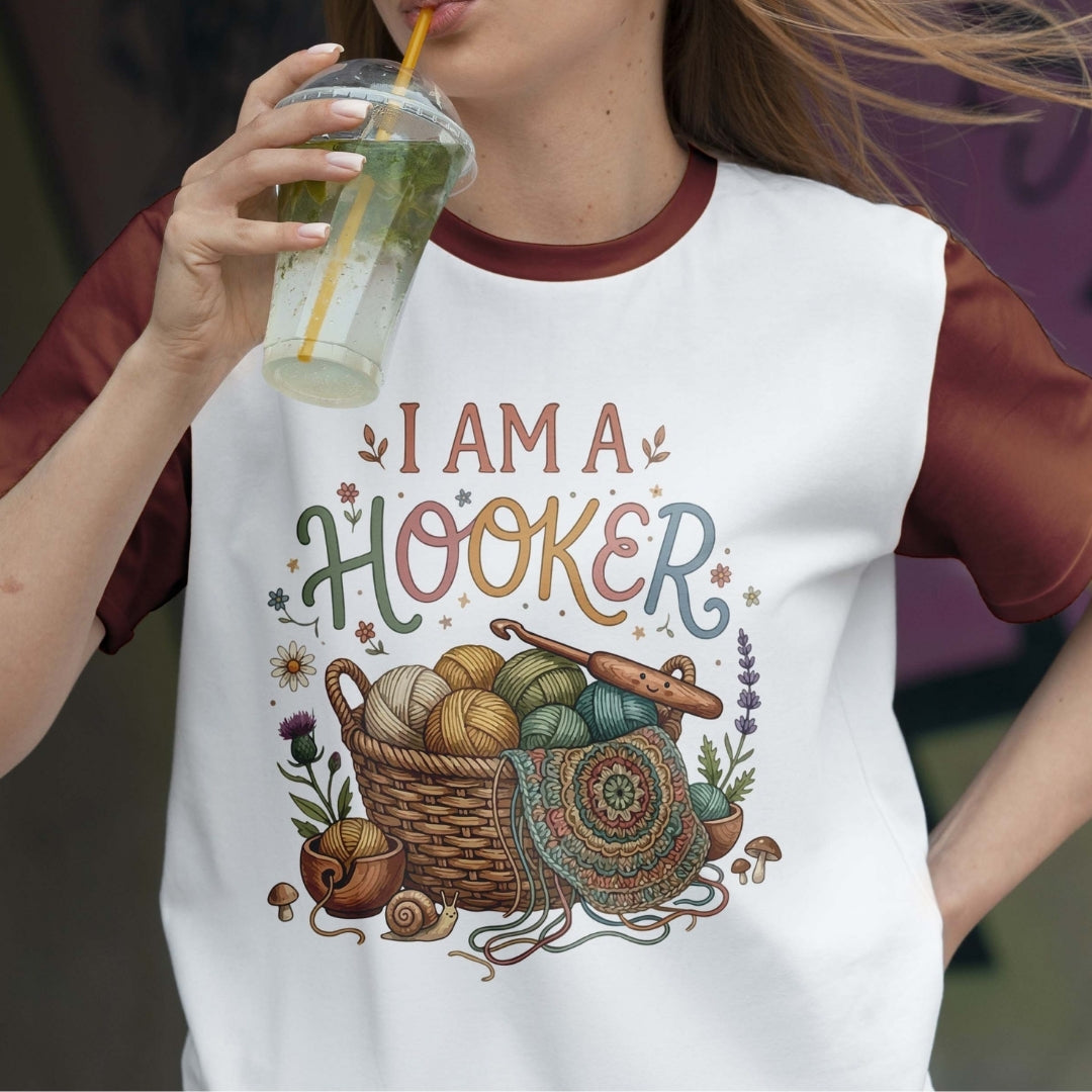 Person wearing a t-shirt with 'I AM A HOOKER' design, holding a drink.